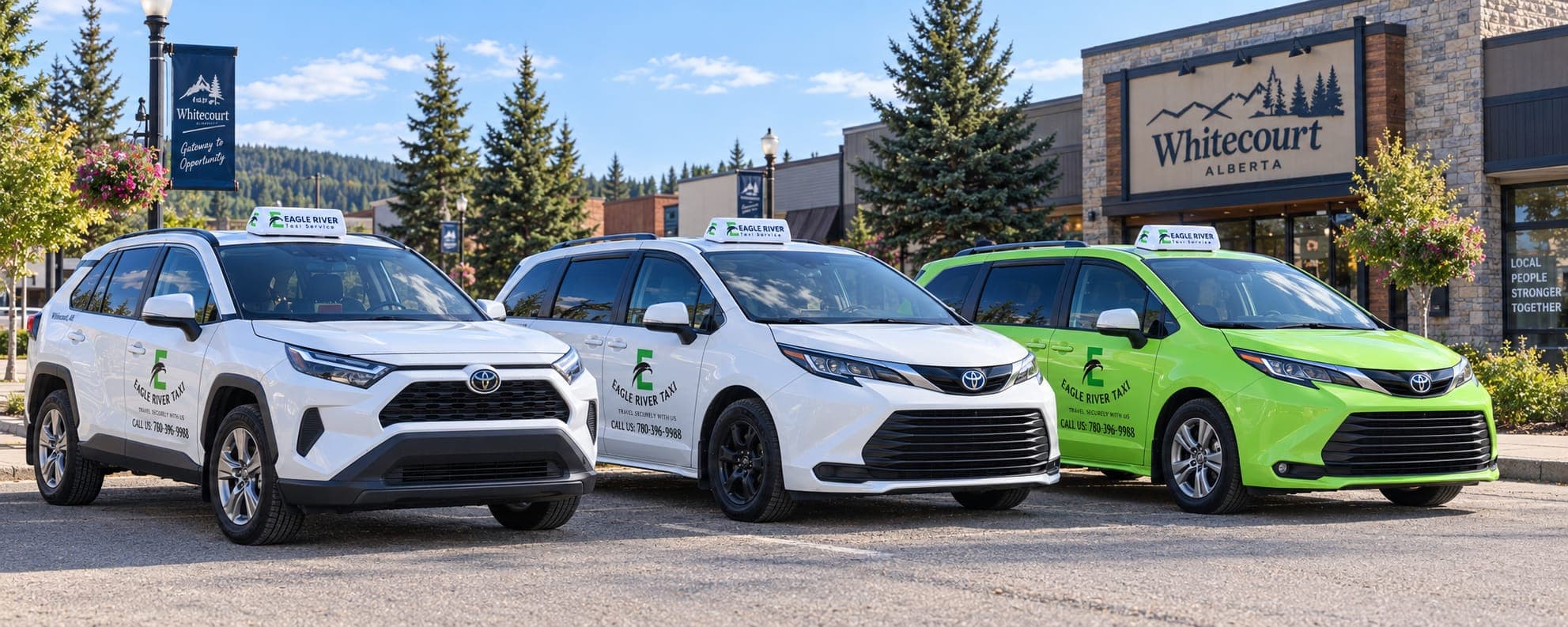 White and green Eagle River Taxi vehicles near a Whitecourt sign.